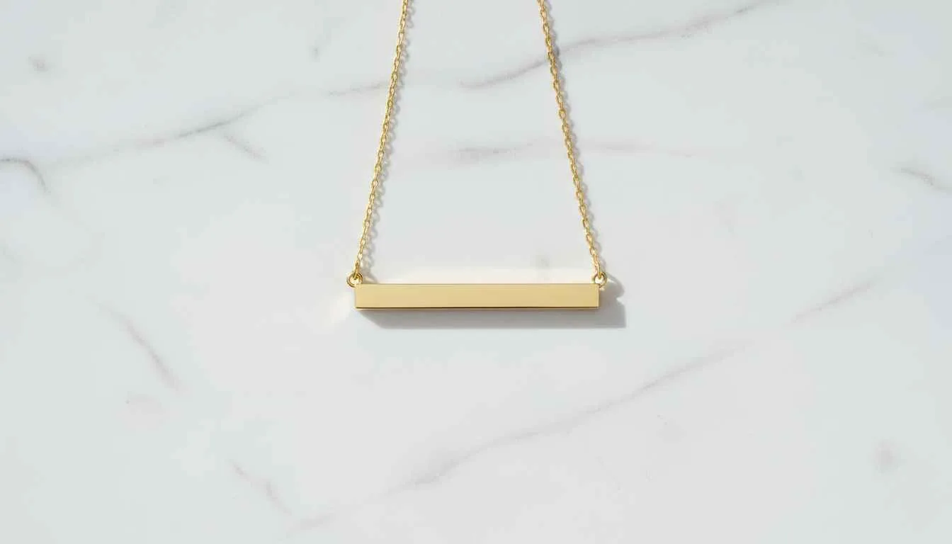 Minimalist 14k gold horizontal bar necklace on white marble — modern everyday jewelry